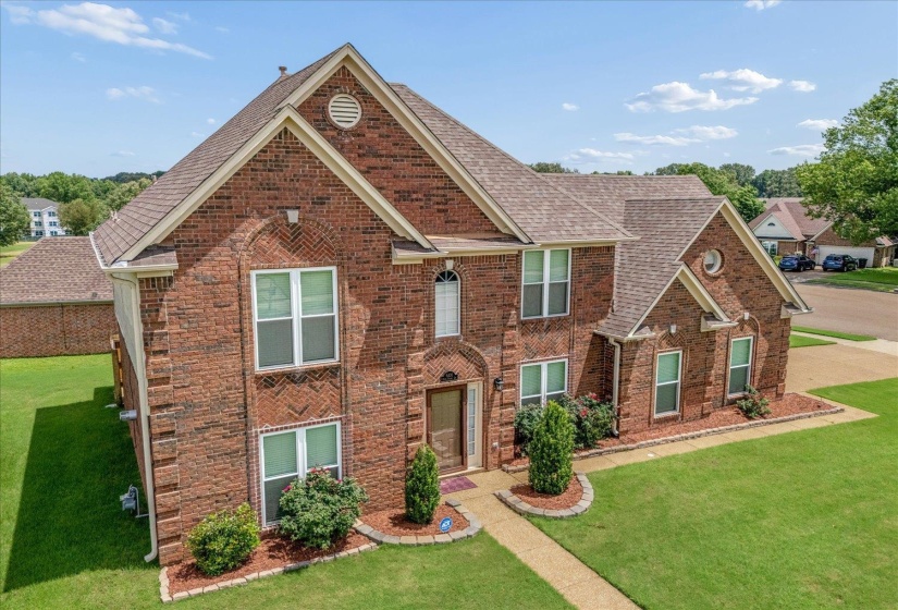 Two-story brick exterior featuring multiple gables and a multi-level roofline