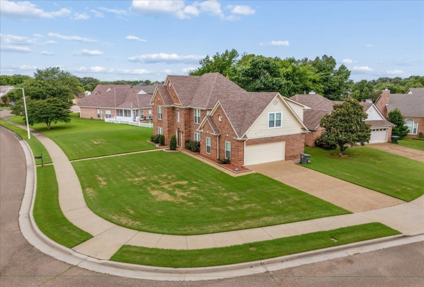 Two-story brick and siding residence featuring a two-car garage, covered entry, and gabled rooflines