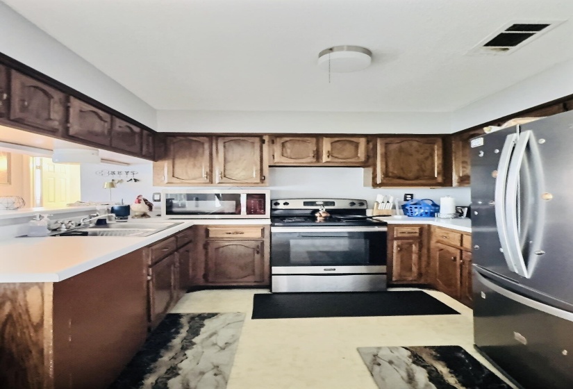 Kitchen featuring wood cabinetry, white countertops, stainless steel appliances, and a built-in microwave