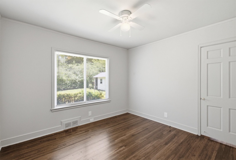 Bright interior space featuring wood-finish flooring, white walls, and a ceiling fan