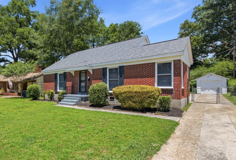 Brick exterior with a gray shingle roof and front porch steps