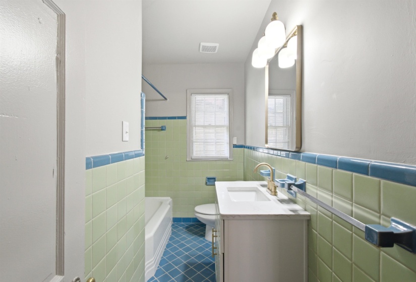 Bathroom featuring a modern vanity with a white countertop and gold-toned faucet