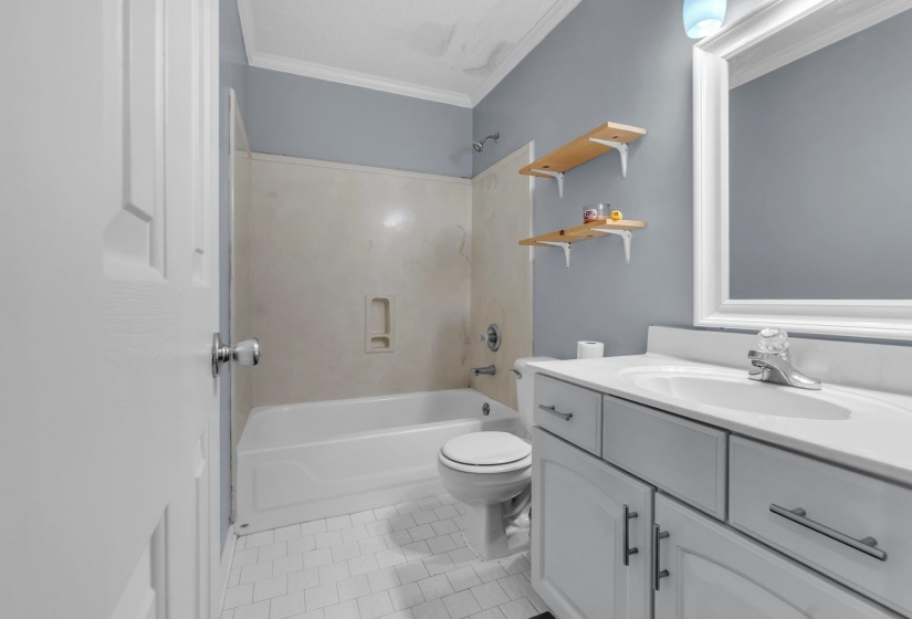 Bathroom featuring a built-in vanity with white countertop, integrated sink, and white cabinetry