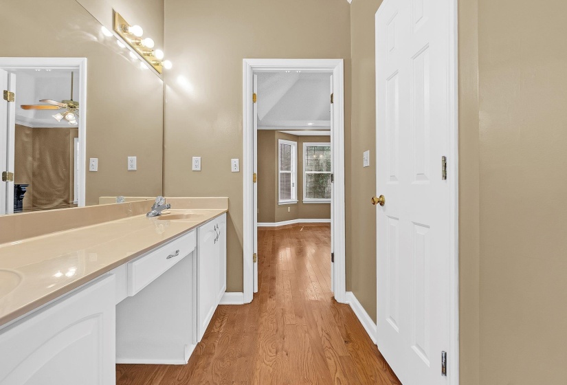 Bathroom vanity with dual sinks, a large mirror, and overhead lighting