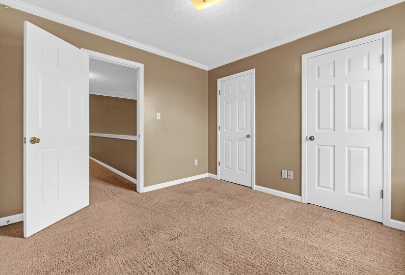 Carpeted room with neutral wall paint and white trim