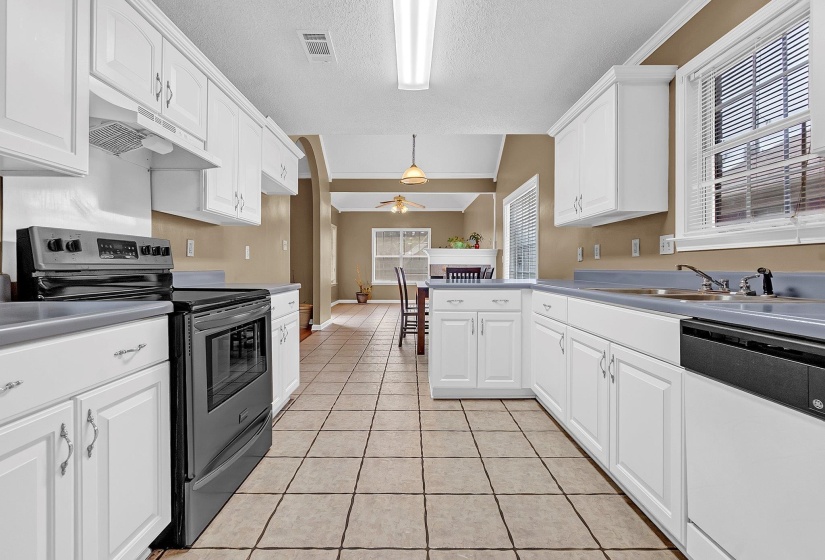 Kitchen featuring white cabinetry, tile flooring, and gray countertops