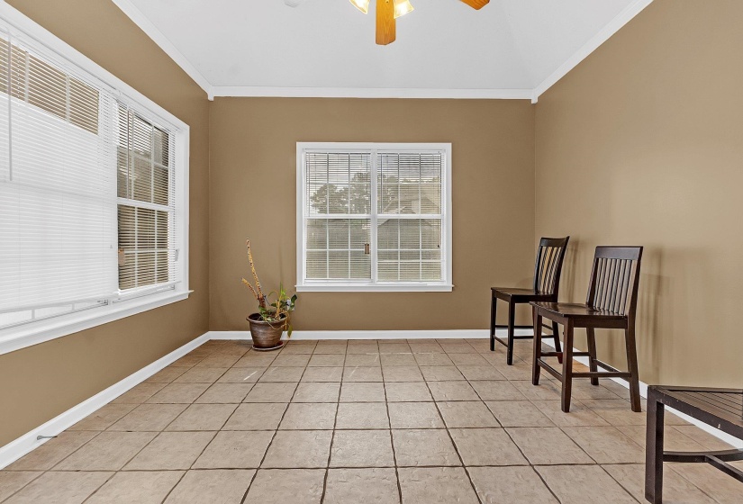 Spacious room featuring neutral-toned walls, tile flooring, and white trim