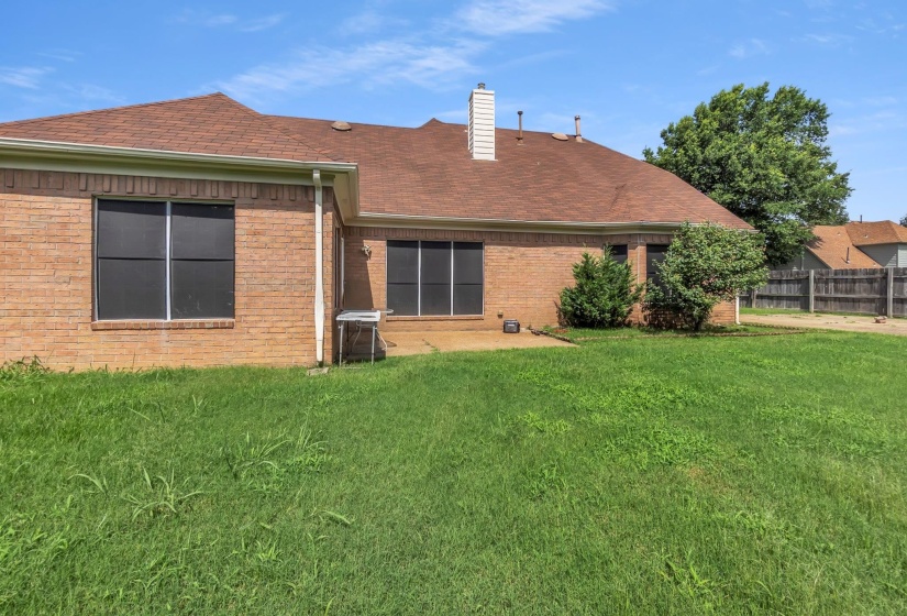 Brick exterior featuring multiple windows with dark screens, a brown shingle roof, and a white chimney